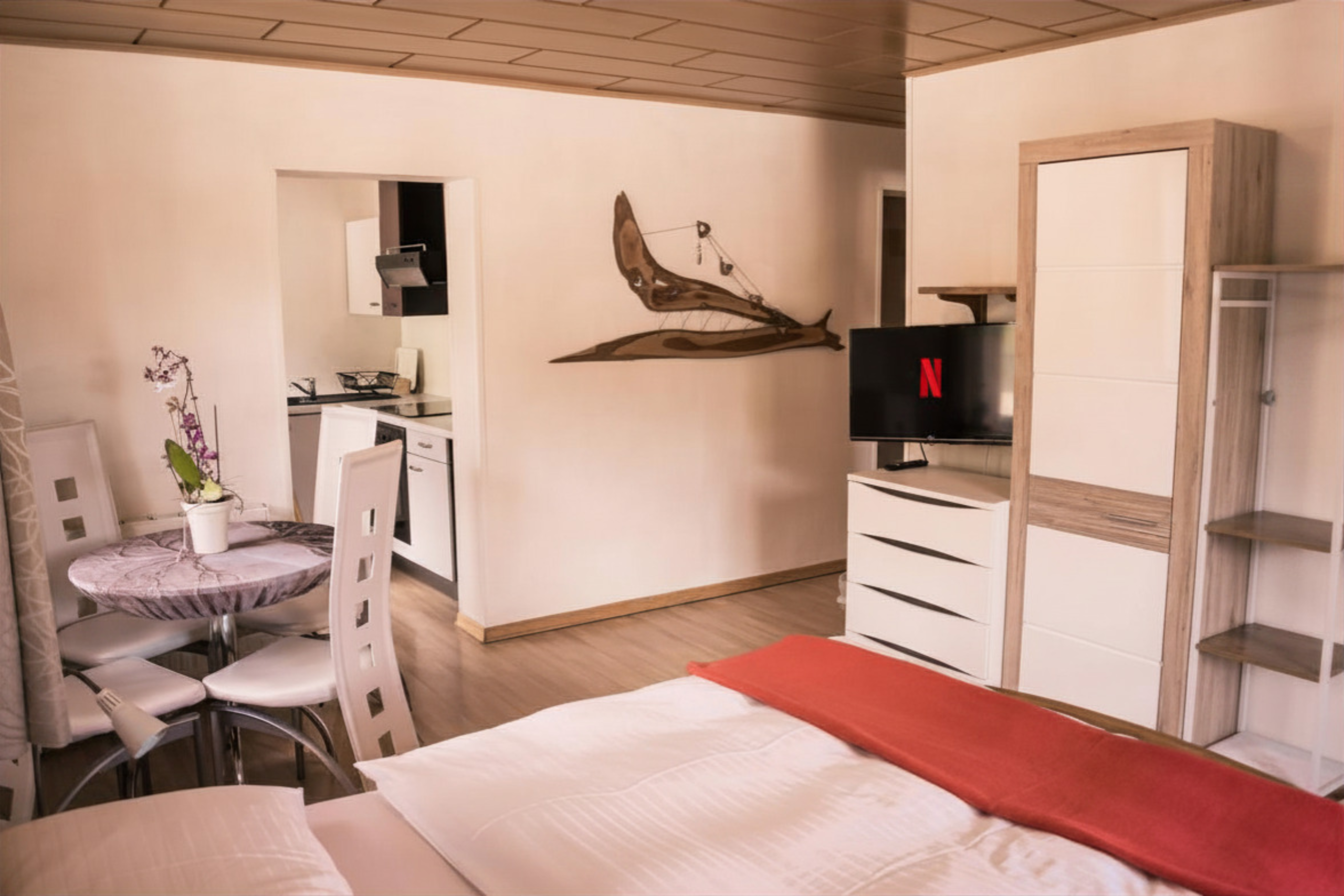 Wohn- & Schlafzimmer mit Blick in die Küche im Appartement Retreat im Landhaus am Hügel